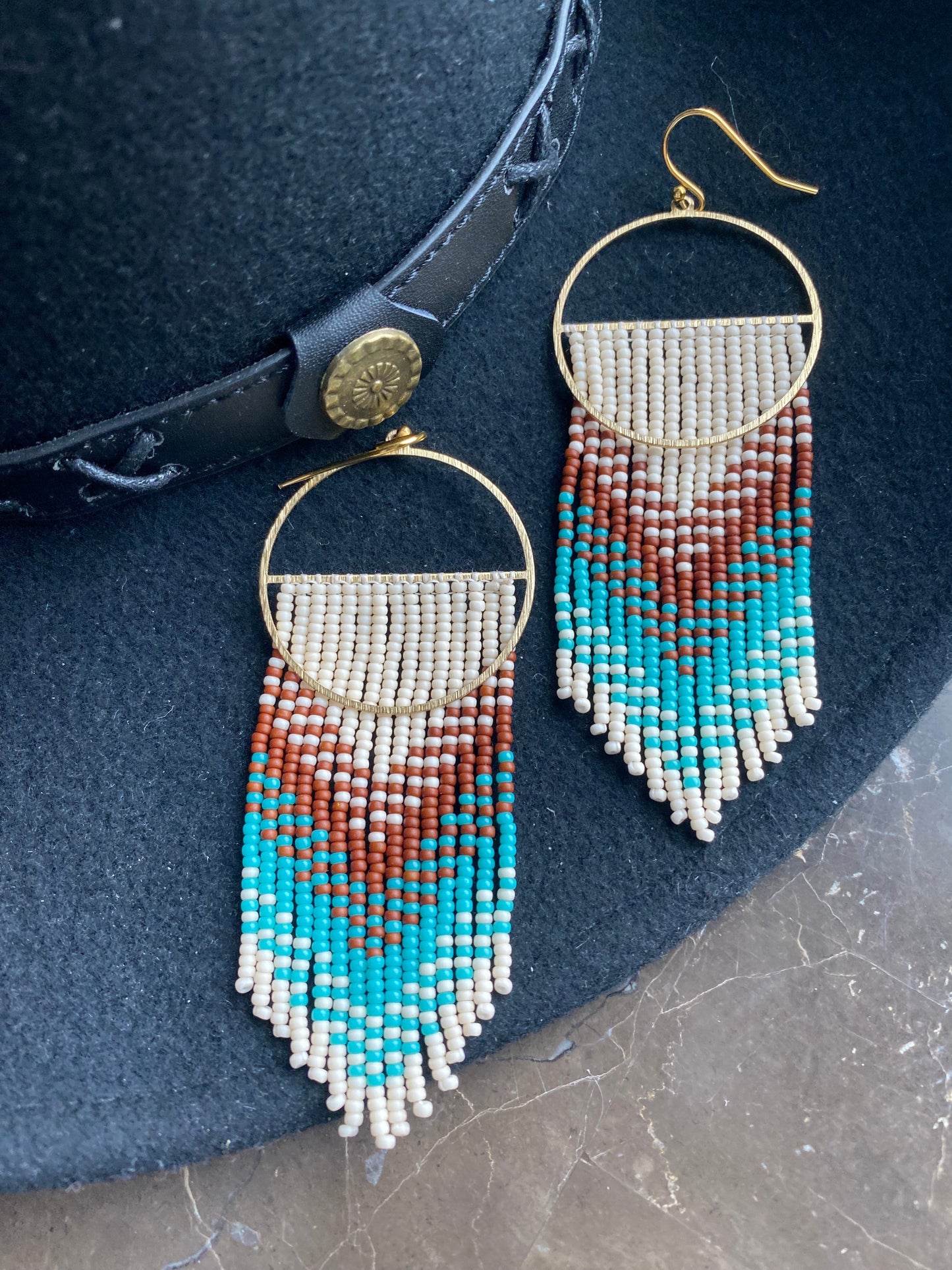 Brown turquoise beige boho earrings on felt cowboy hat