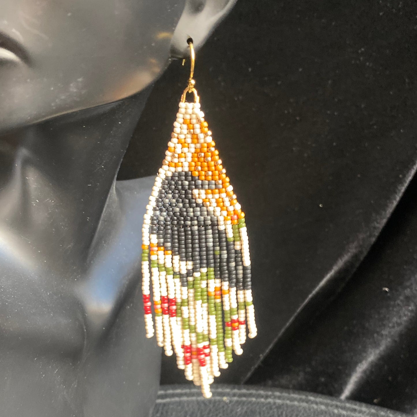 Beaded raveearring on a mannequin ear with a black background