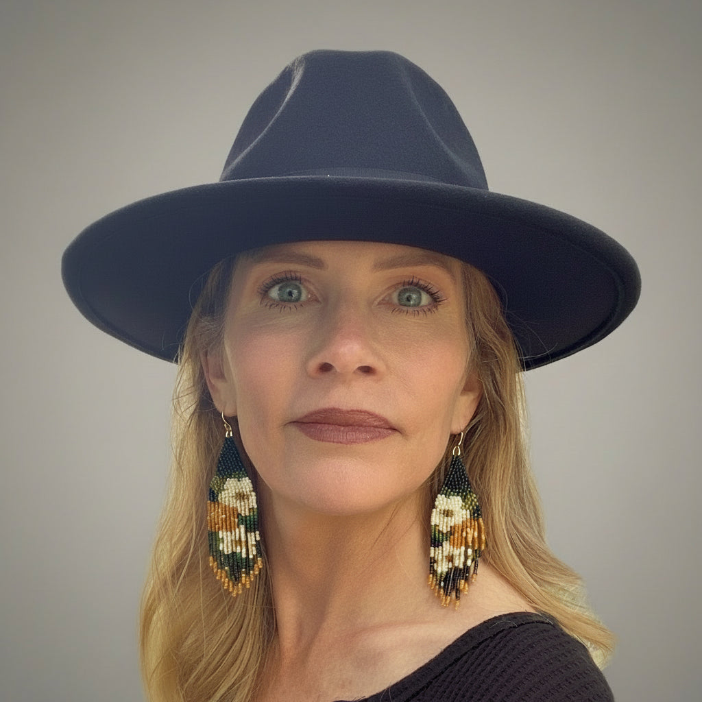 Woman wearing a black hat and colorful earrings outdoors badlands beadwork