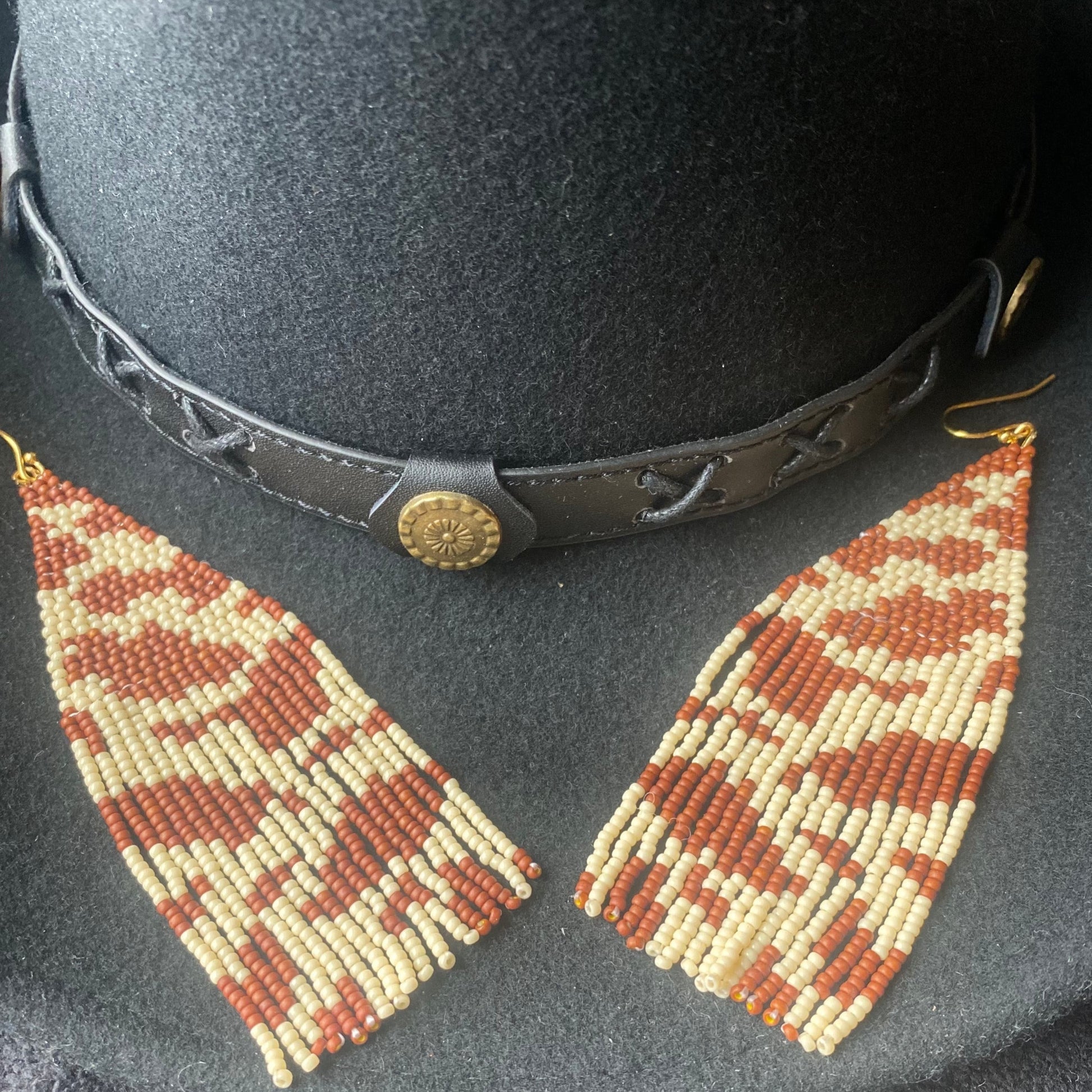 Cowhide beaded earrings on cowboy hat 