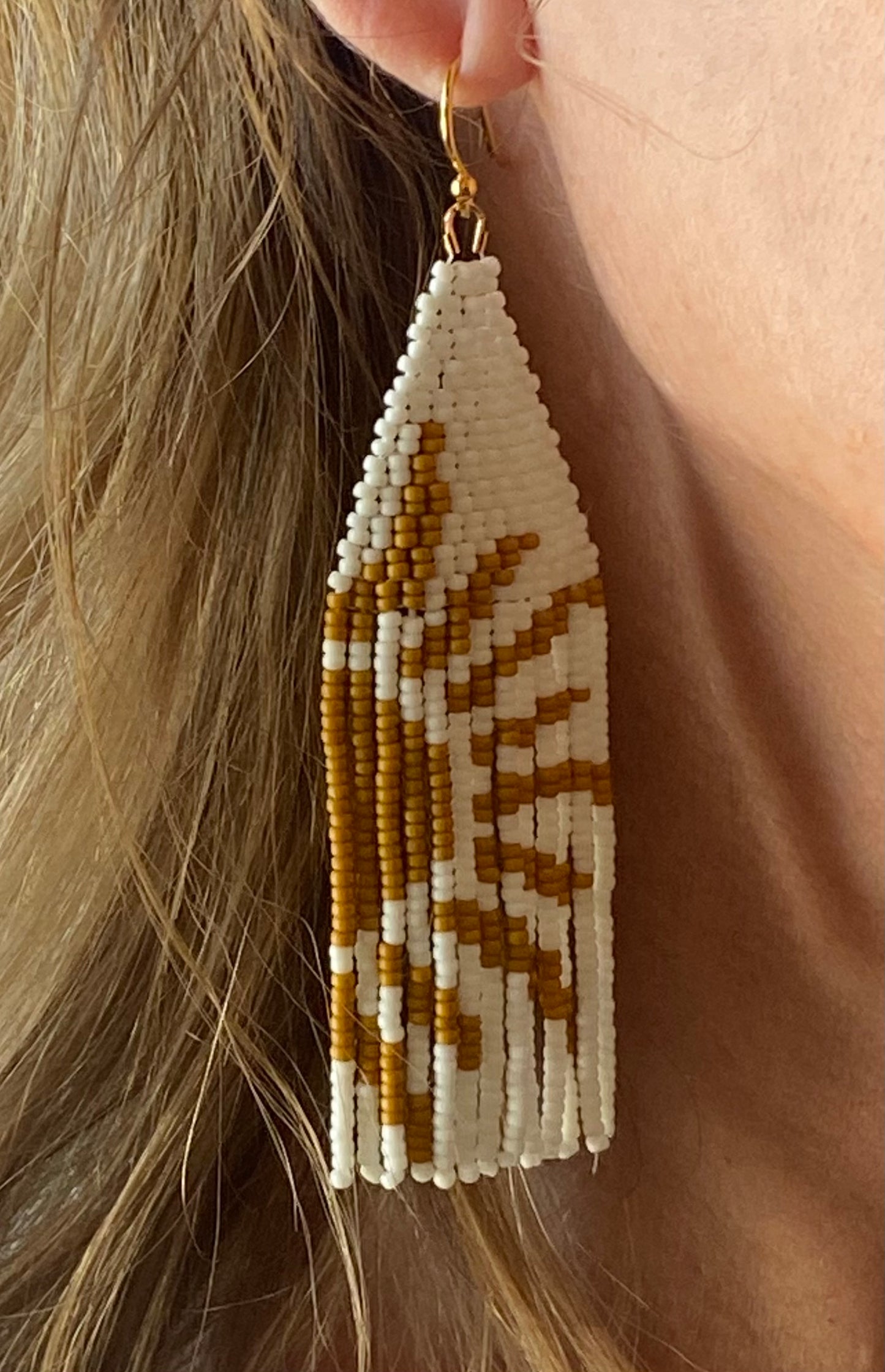 Mustard white boho earrings on ear