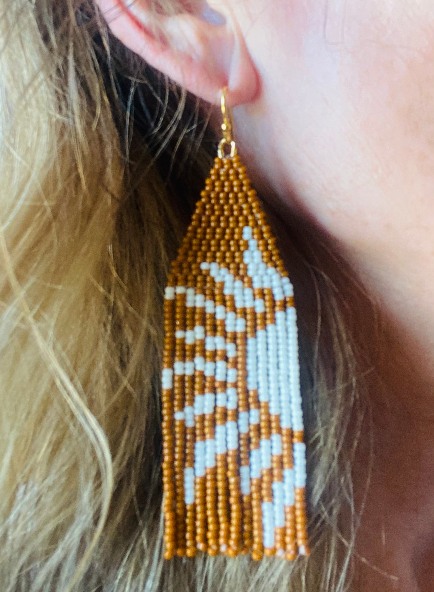 Orange sun beaded earring on model